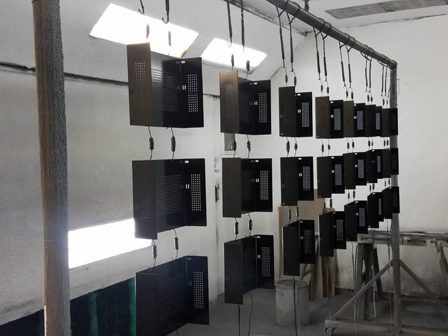 Rows of coated sheet metal panels hanging in the shop